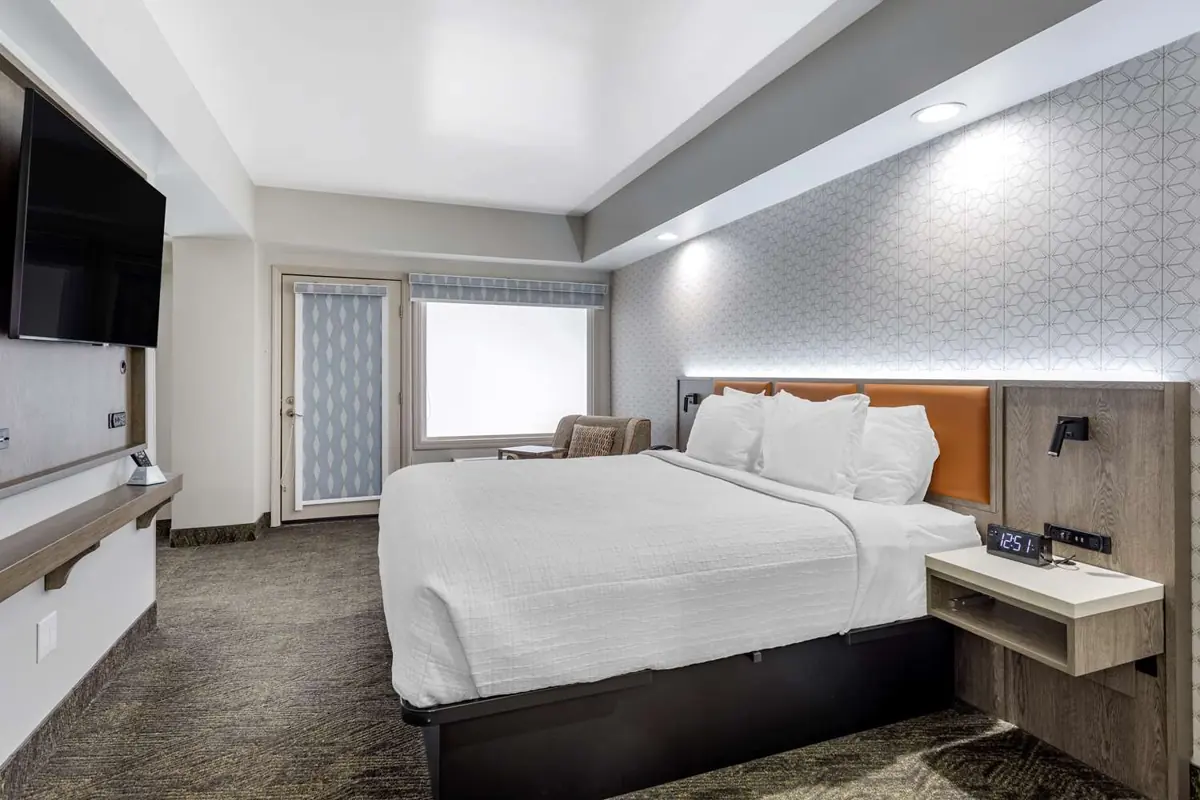 King bed area with balcony access in the Family Bunk Bed Suite.