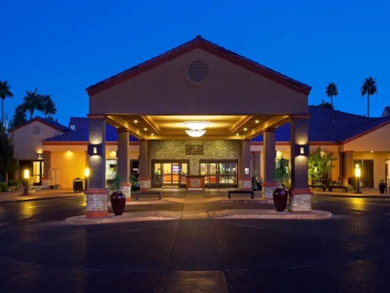 Covered resort entrance lit at dusk with a tiled roof.
