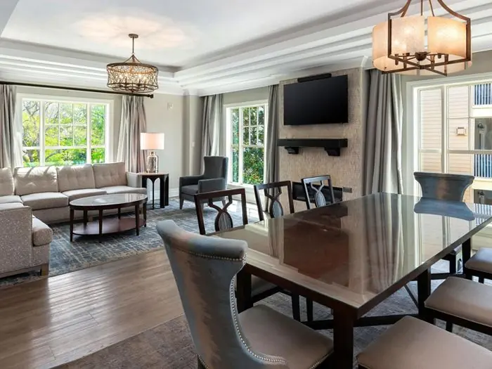 Open living and dining area with sofa, dining table and TV.