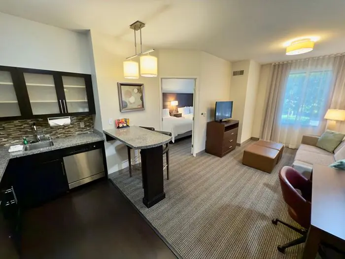 Kitchen and living area with view into bedroom.