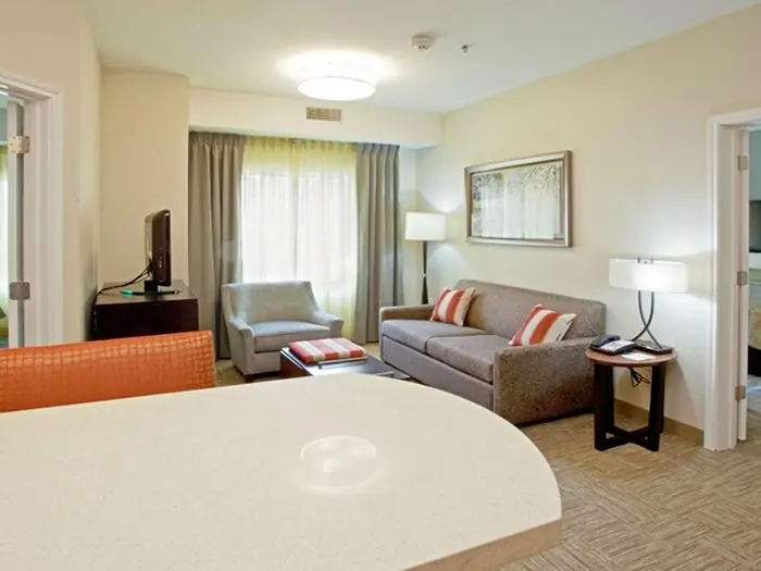 Living area with sofa, armchairs and dining counter.