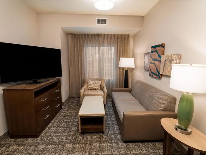 Living area with sofa, armchair and TV.