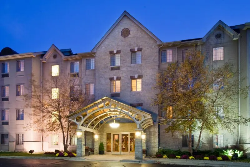 Hotel entrance with an arched canopy and a stone and brick facade at dusk.
