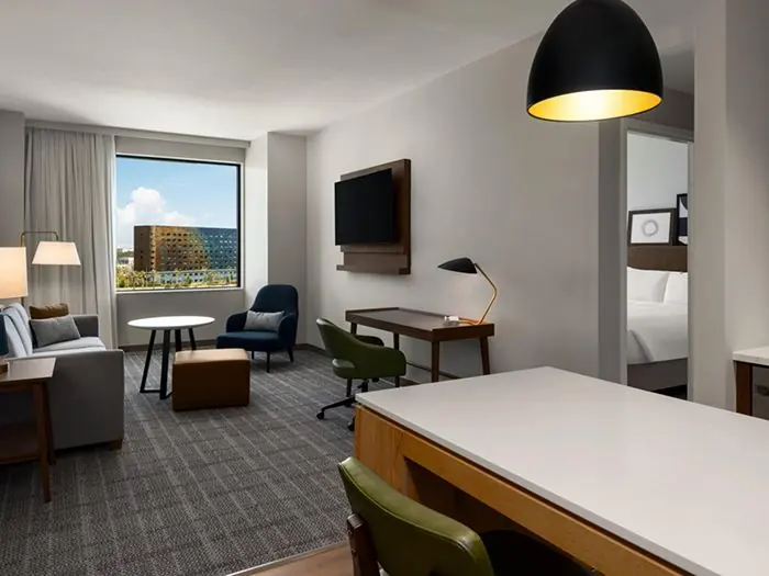 Living area with sofa, desk and table, bedroom door.